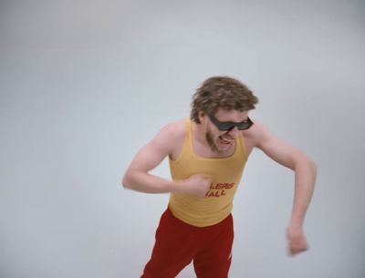 a man in a yellow tank top and red pants