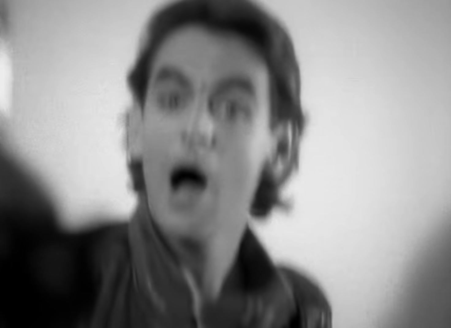 a blurry photo of a man making a surprised face