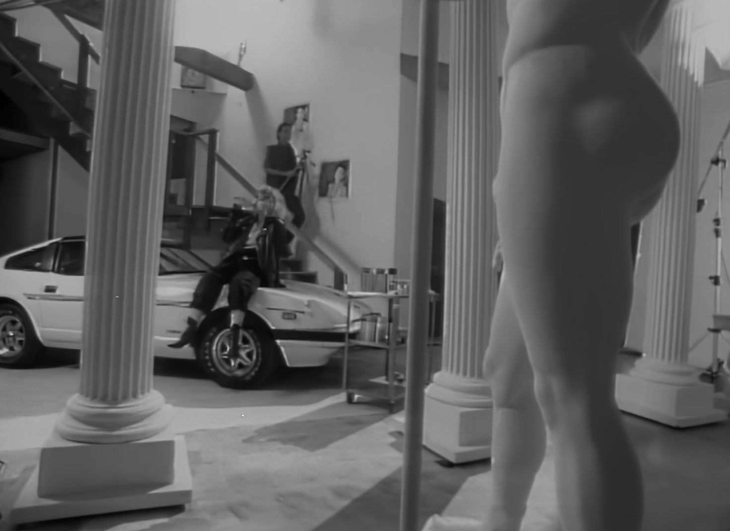 a man riding a scooter next to a statue of a woman