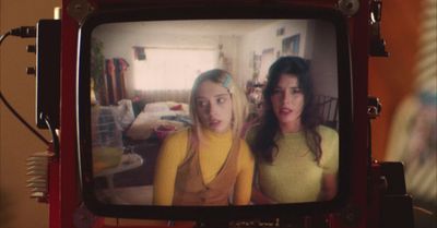 two young women on a television screen in a living room