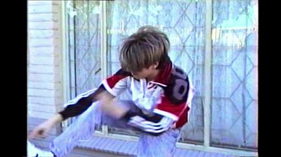 a boy in a red and white jacket leaning on a window sill