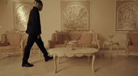 a man walking through a living room filled with furniture