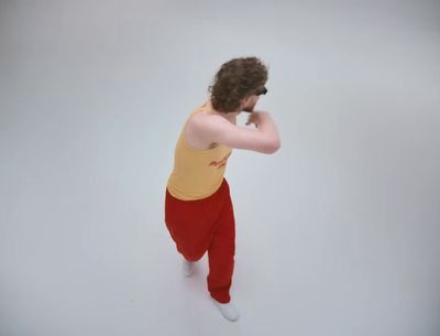 a man in a yellow tank top and red pants