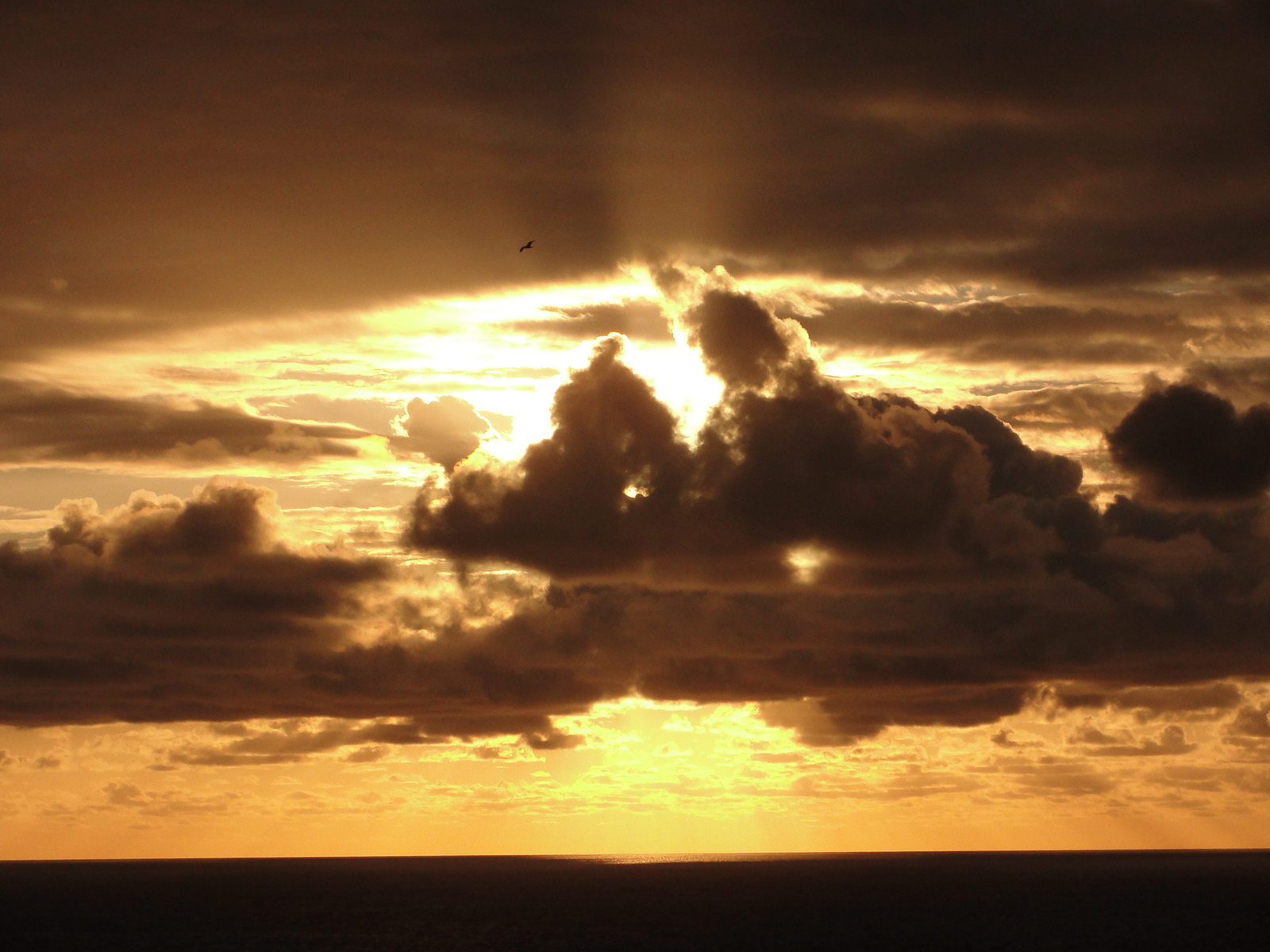 the sun is shining through the clouds over the ocean