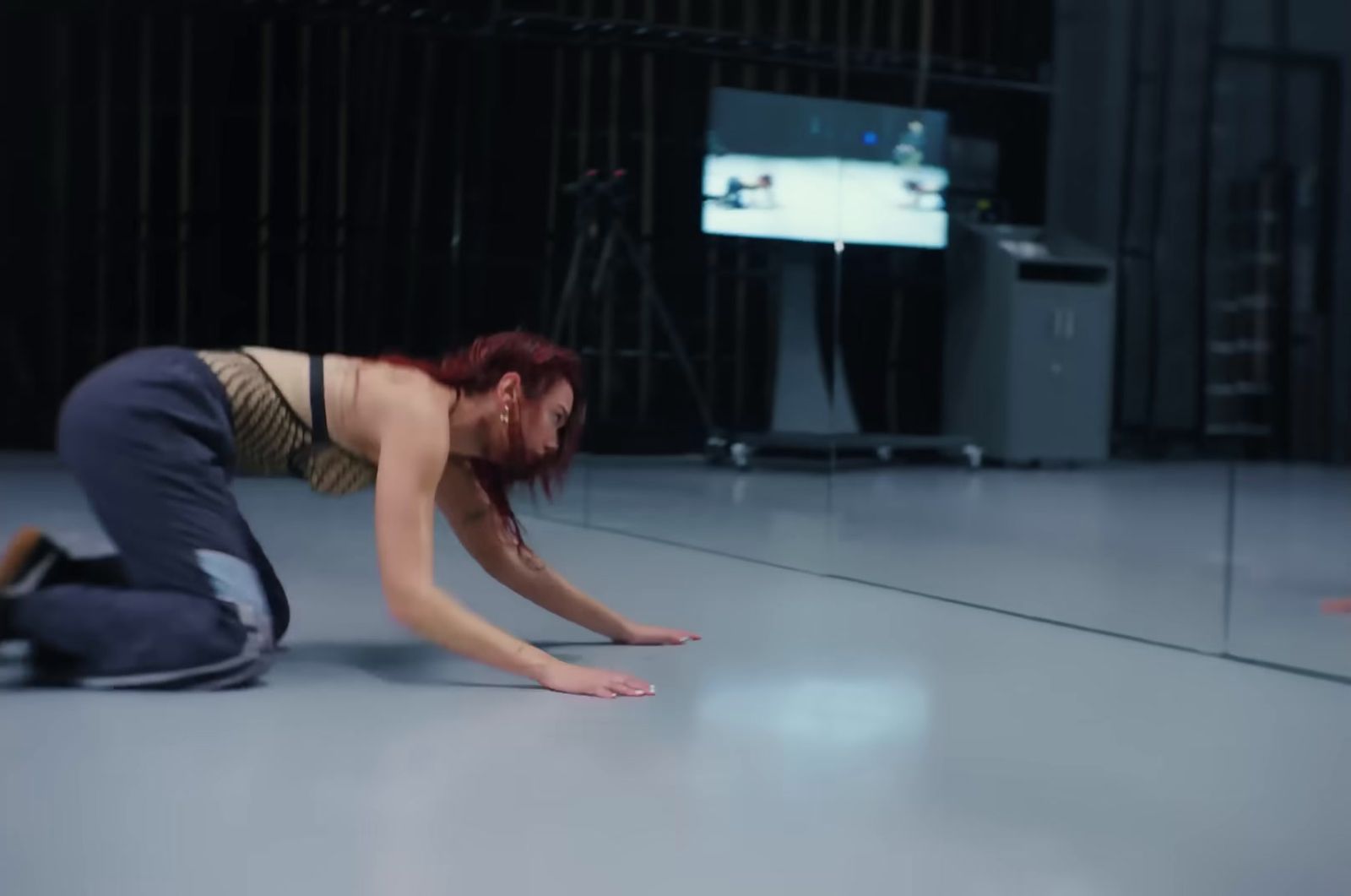 a woman is kneeling on the floor in front of a mirror