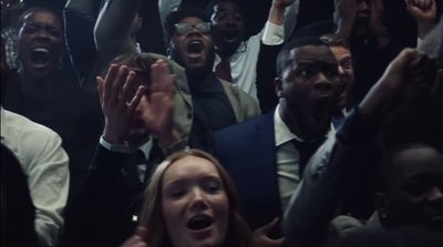 a group of people standing around each other with their hands in the air