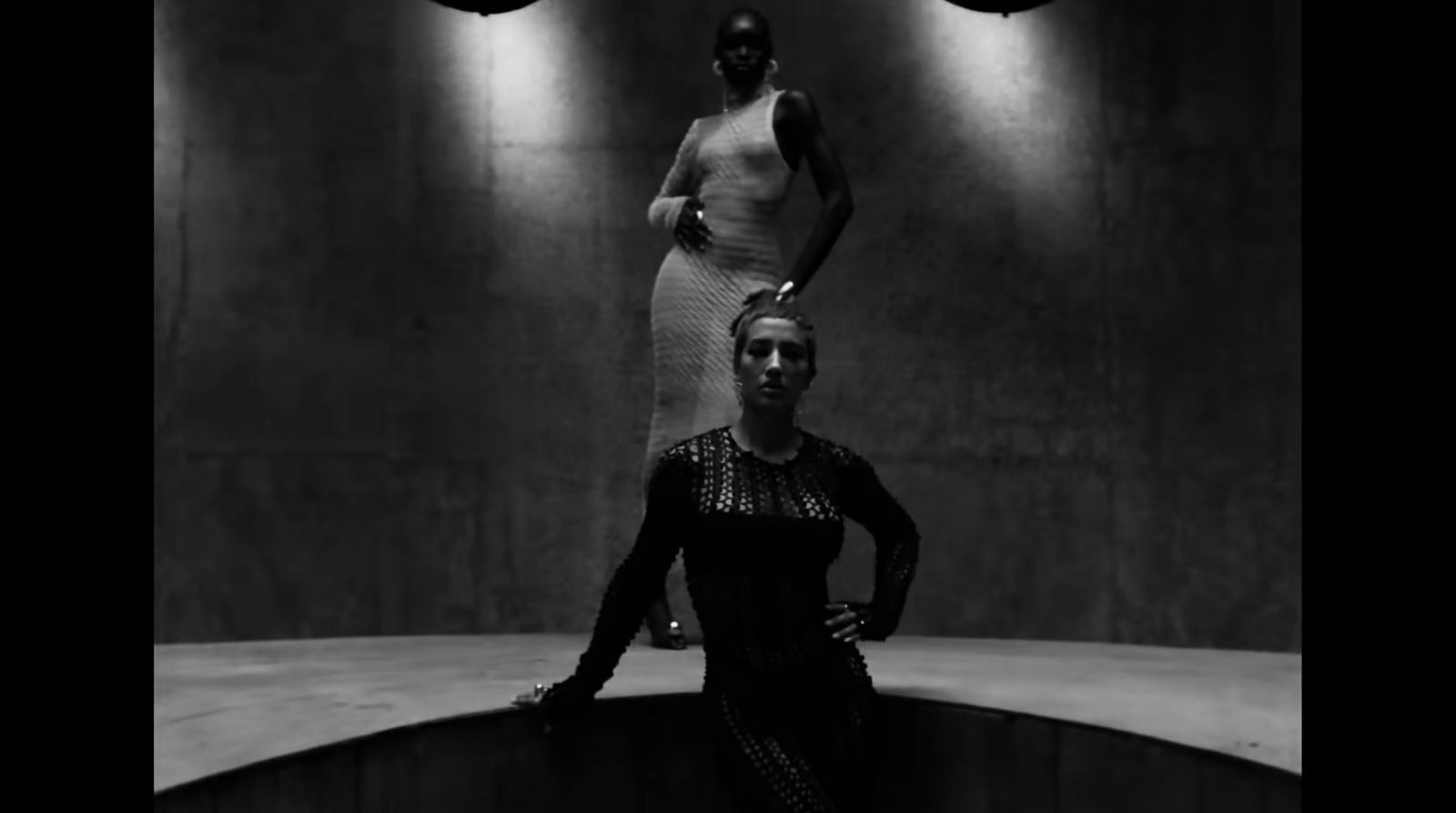 a black and white photo of a woman standing next to a mannequin