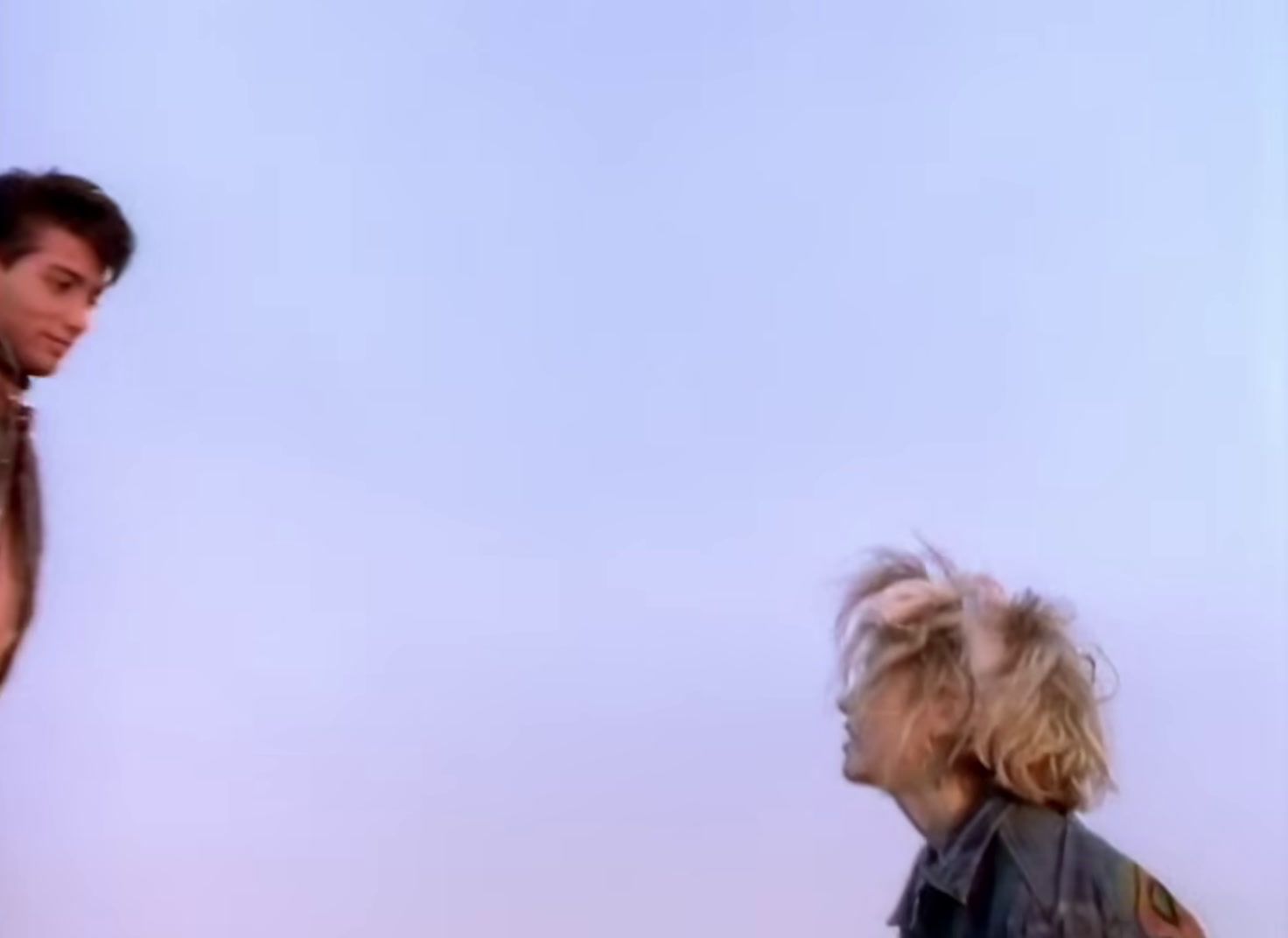 a man standing next to a woman flying a kite