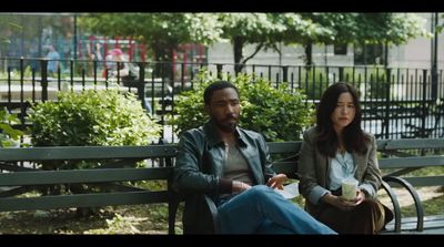 a man and a woman sitting on a park bench