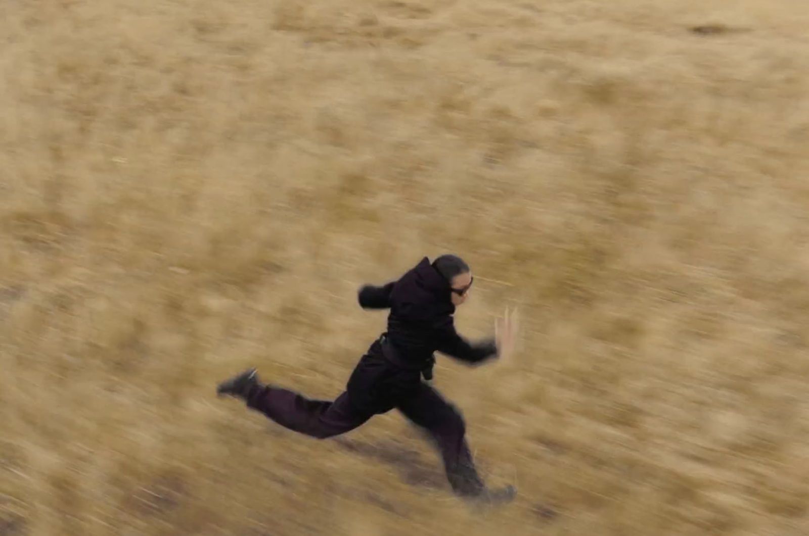 a man running through a field with a frisbee in his hand