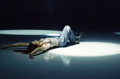 a woman laying on the ground with her head on a man's back