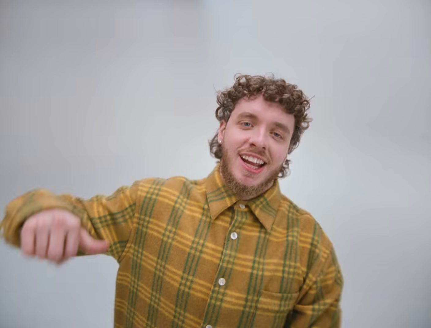 a man with curly hair is pointing at something