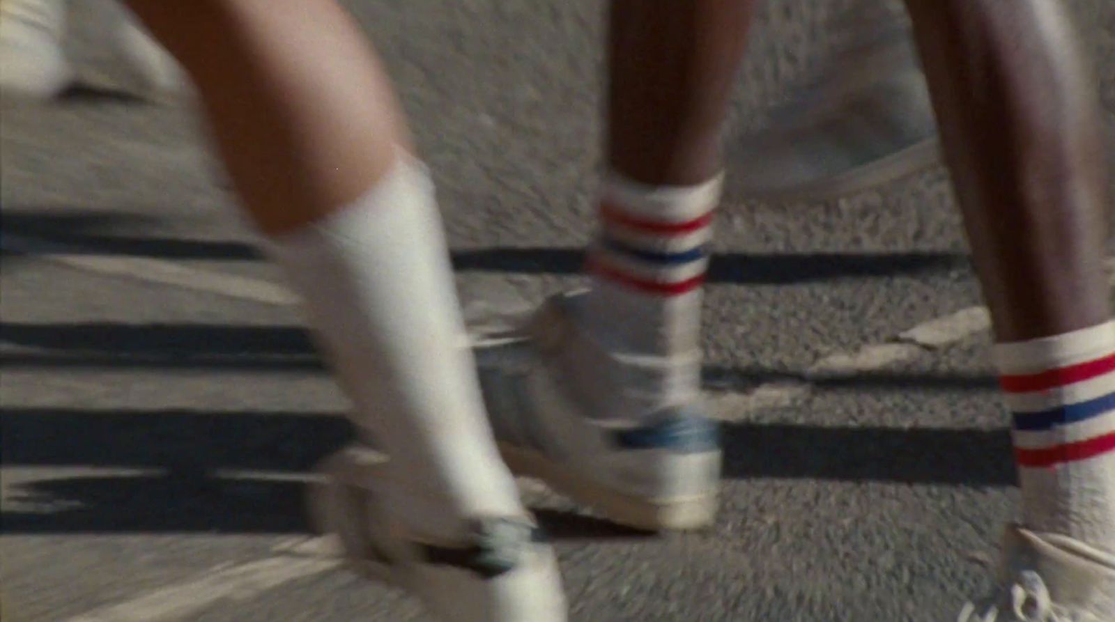 a couple of people riding skateboards down a street