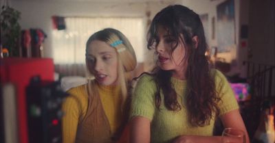 two young women sitting next to each other in a room