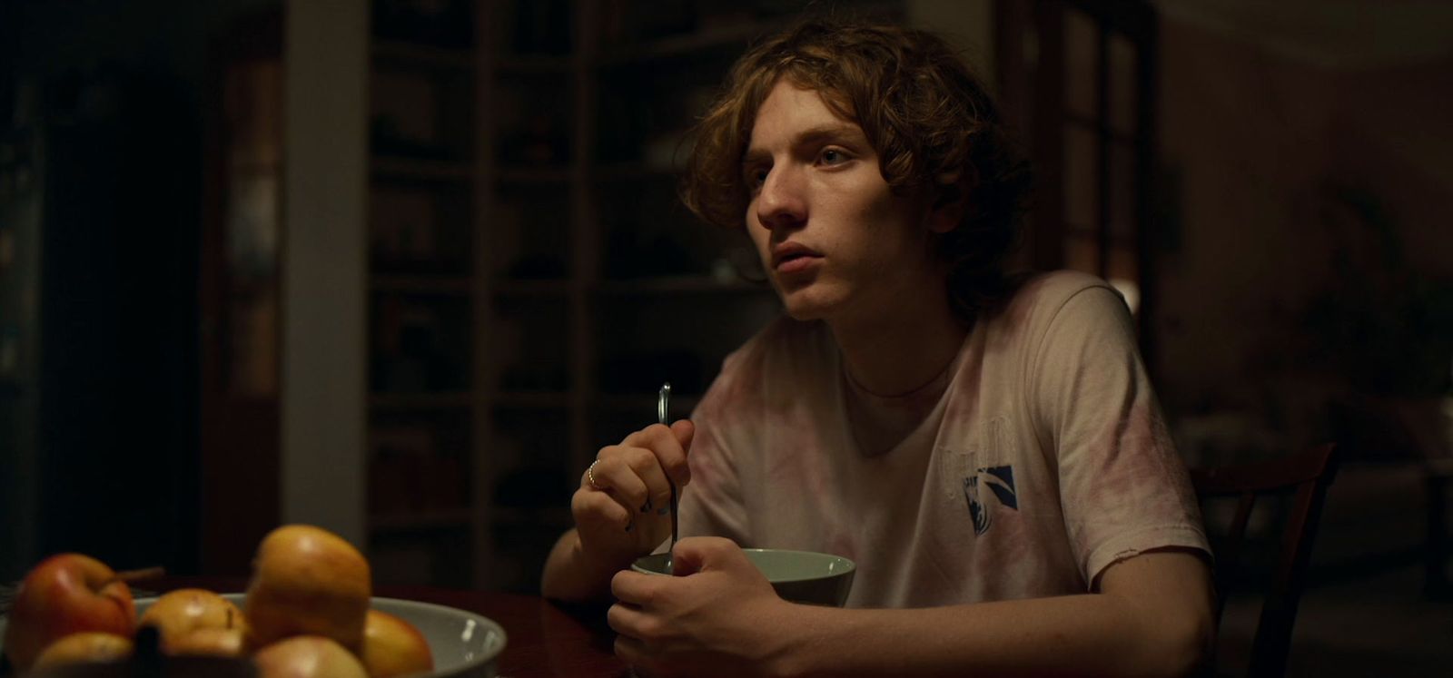 a man sitting at a table with a bowl of fruit