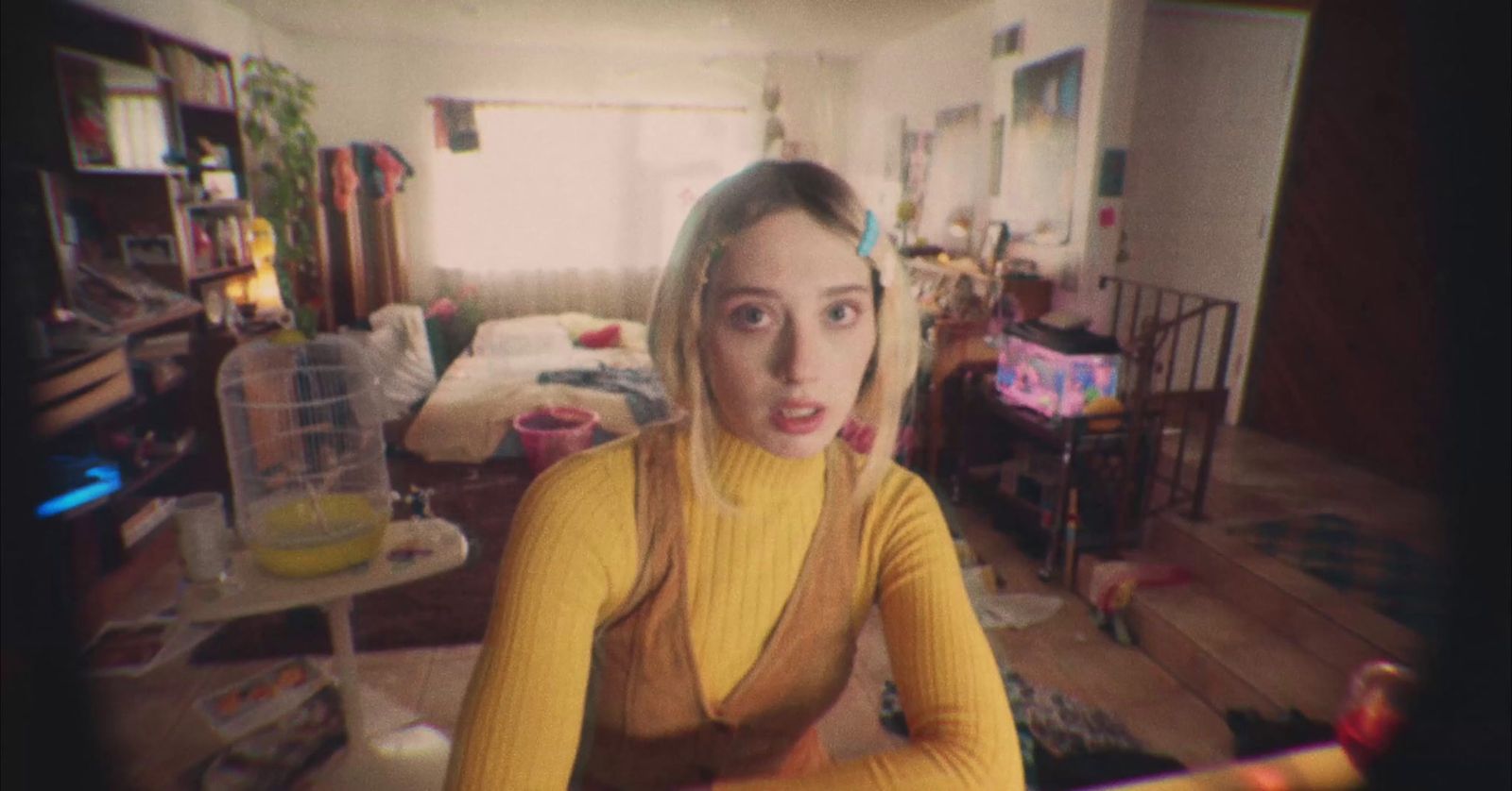 a woman in a yellow sweater is sitting in a living room