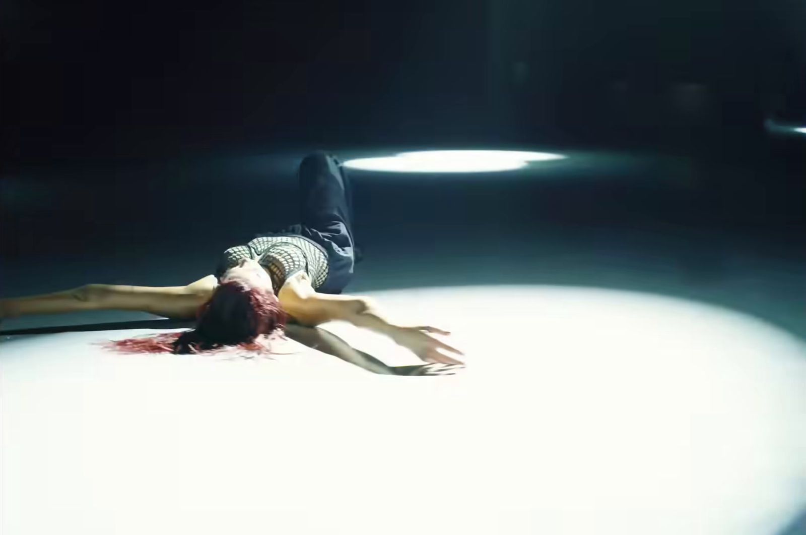 a woman laying on the floor in a dark room