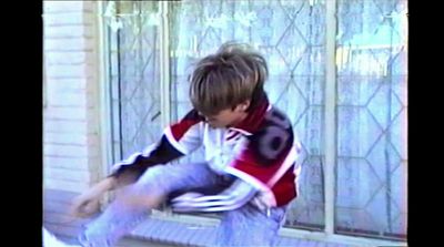 a boy sitting on a window sill with his hands in his pockets