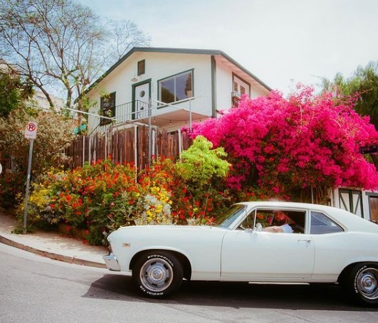 a white car parked in front of a house