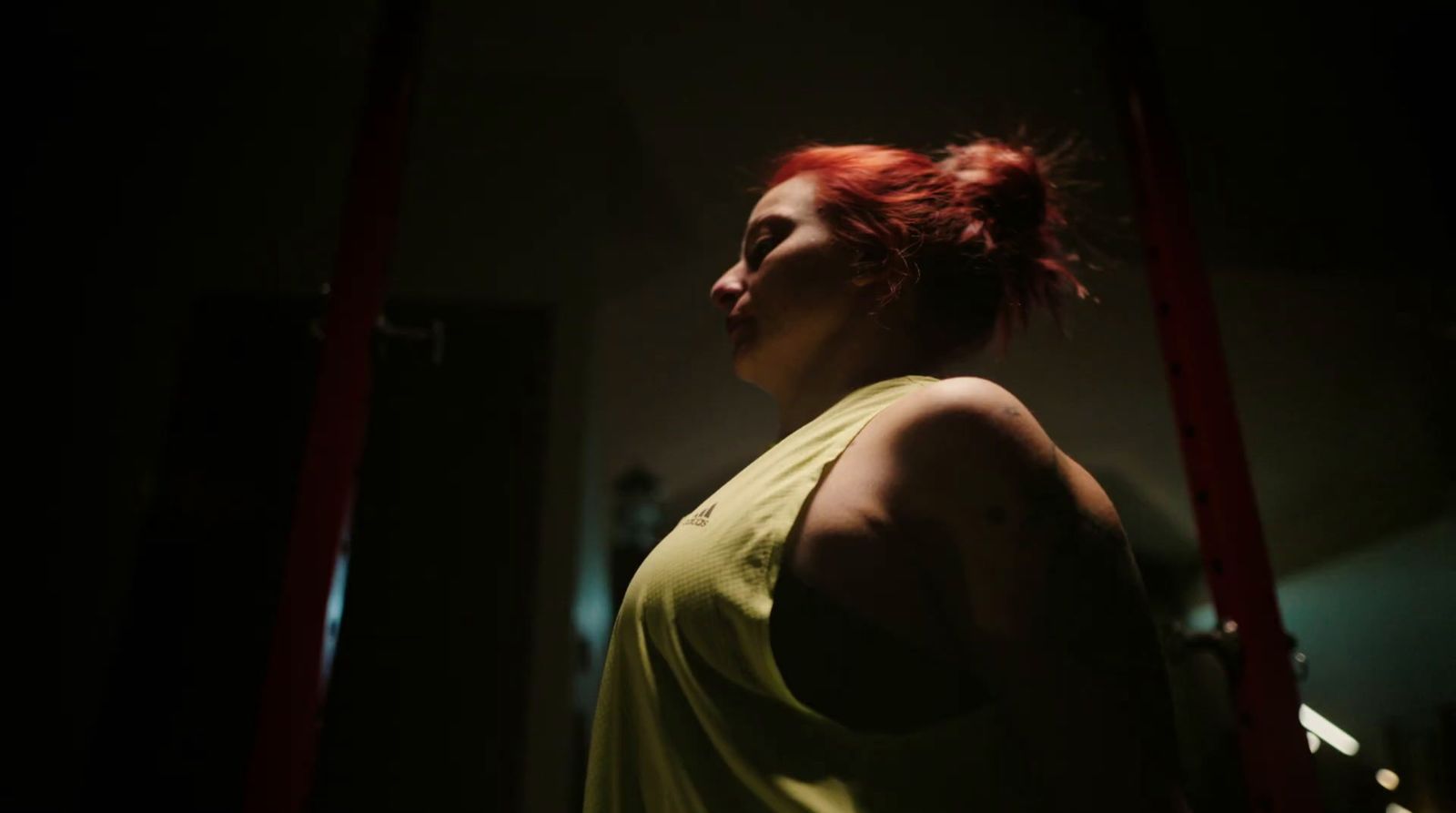 a woman with red hair standing in a dark room