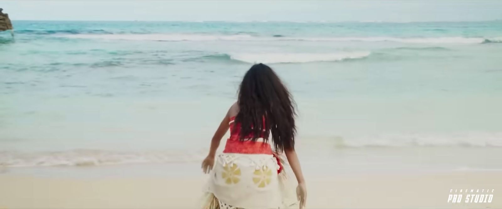 a woman standing on a beach next to the ocean