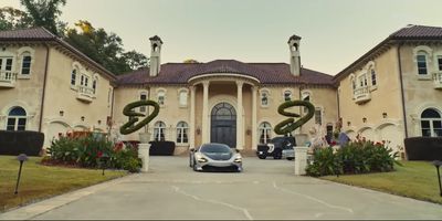 a car parked in front of a large house