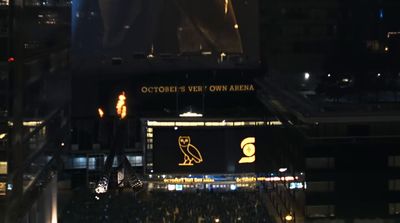 a crowd of people standing around a stadium at night