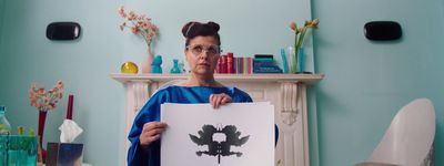 a woman holding a piece of paper in front of a fireplace