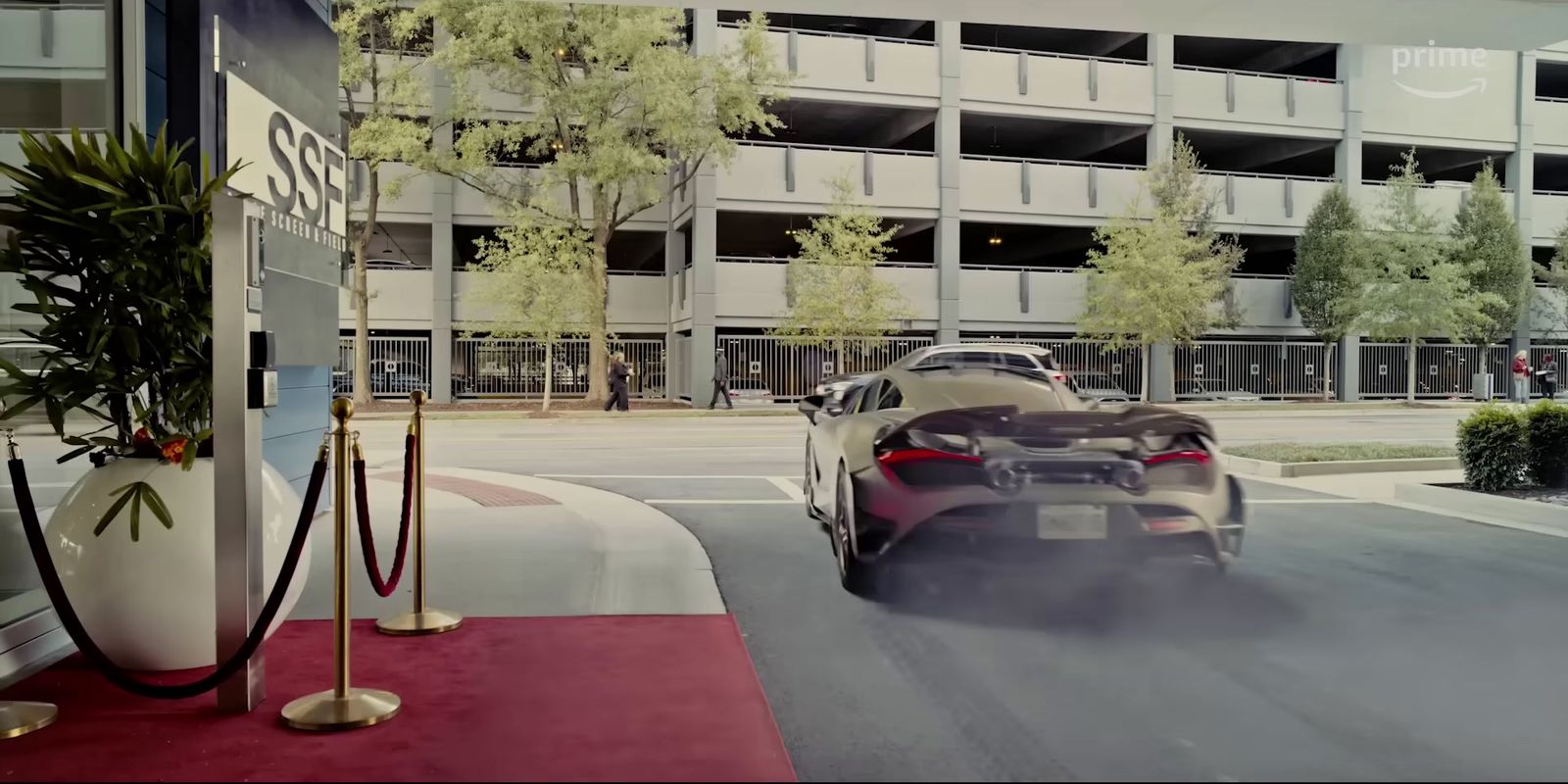 a car driving down a street next to a tall building