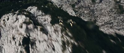 a couple of people riding skis down a snow covered slope