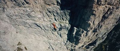 a man climbing up the side of a mountain