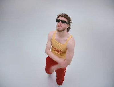 a man in a yellow tank top and red pants