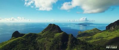 an aerial view of a mountain range with a body of water in the distance