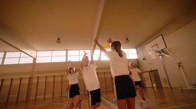 a group of young women playing a game of basketball