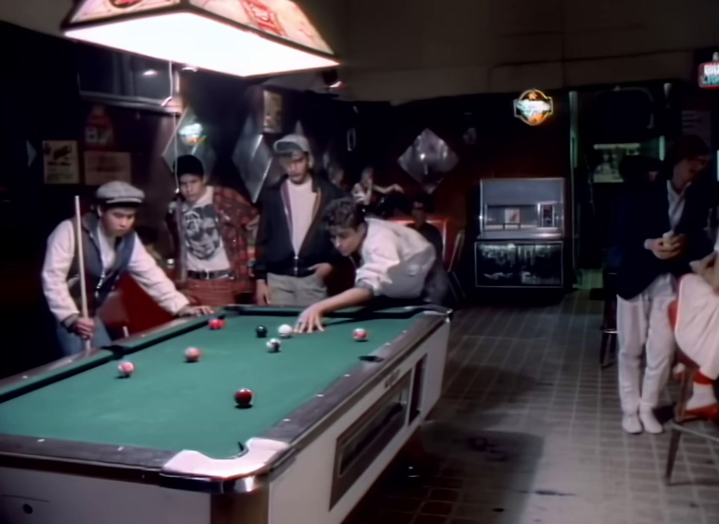 a group of men standing around a pool table