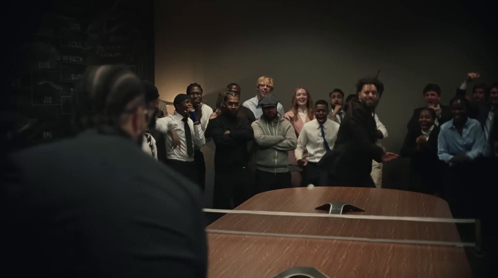 a group of people standing around a wooden table