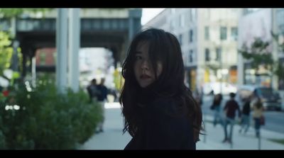 a woman standing on a sidewalk in a city