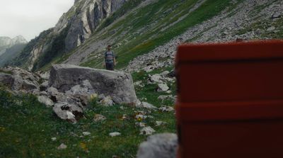 a red bench sitting on top of a lush green hillside