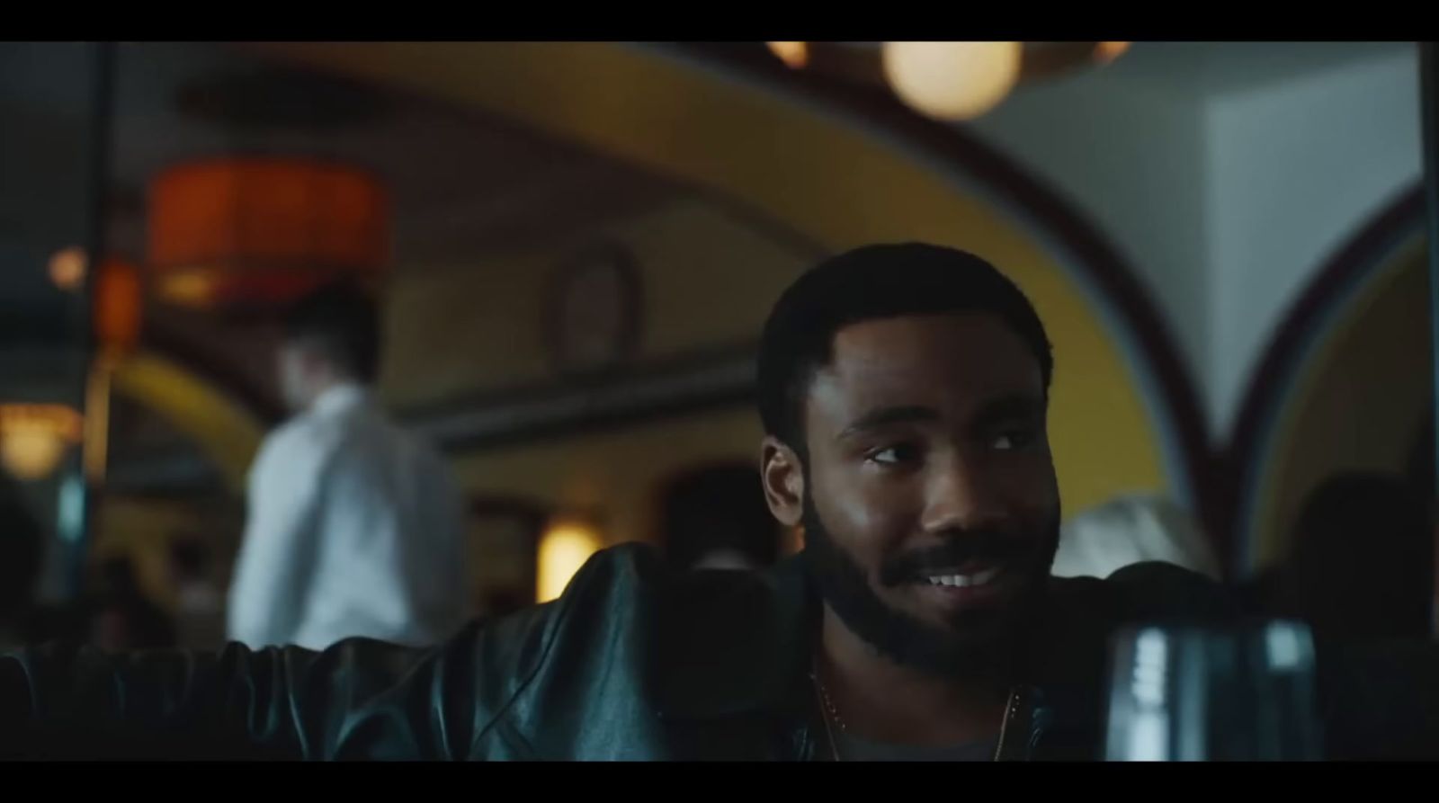 a man in a leather jacket sitting at a table