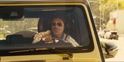 a man in sunglasses driving a yellow jeep