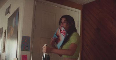 a woman standing in a room holding a bottle of wine