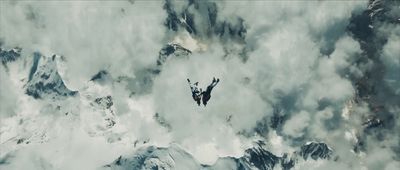 a person in the air above a mountain