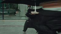 a man walking down a street holding an umbrella