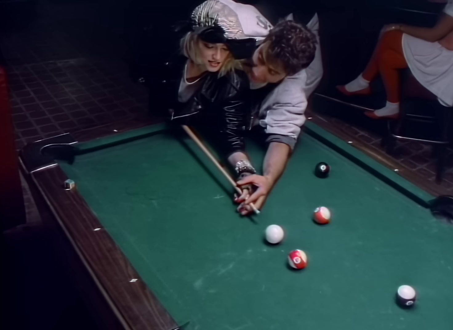 a man and a woman playing a game of pool