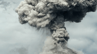 a large plume of smoke billowing out of the top of a mountain