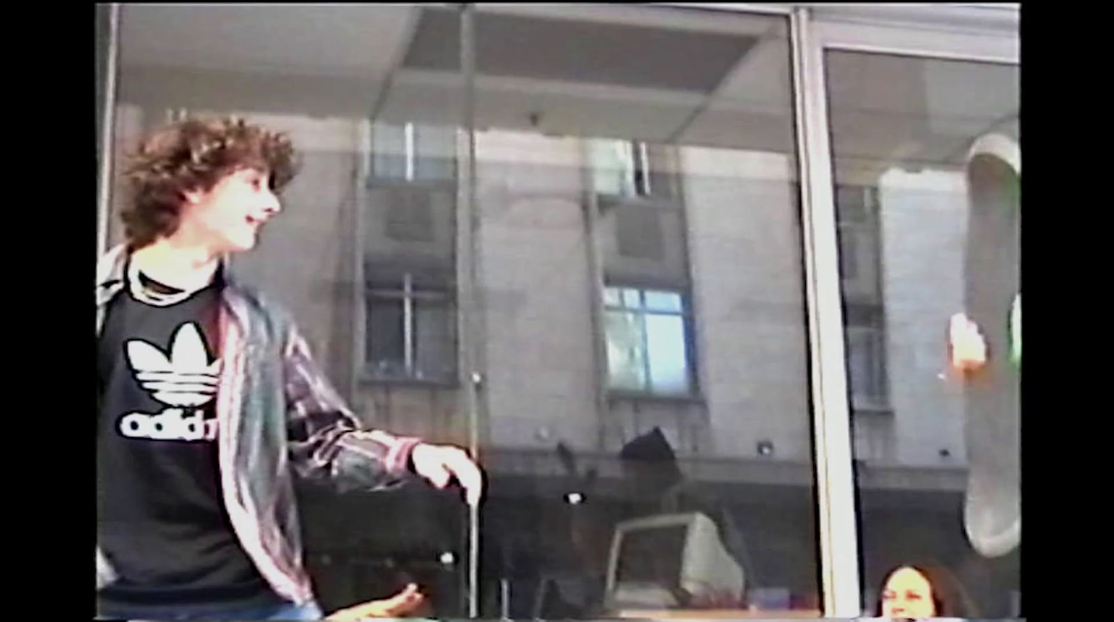 a young man standing in front of a glass window