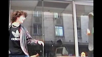 a young man standing in front of a glass window