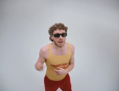 a man in a yellow tank top and red pants