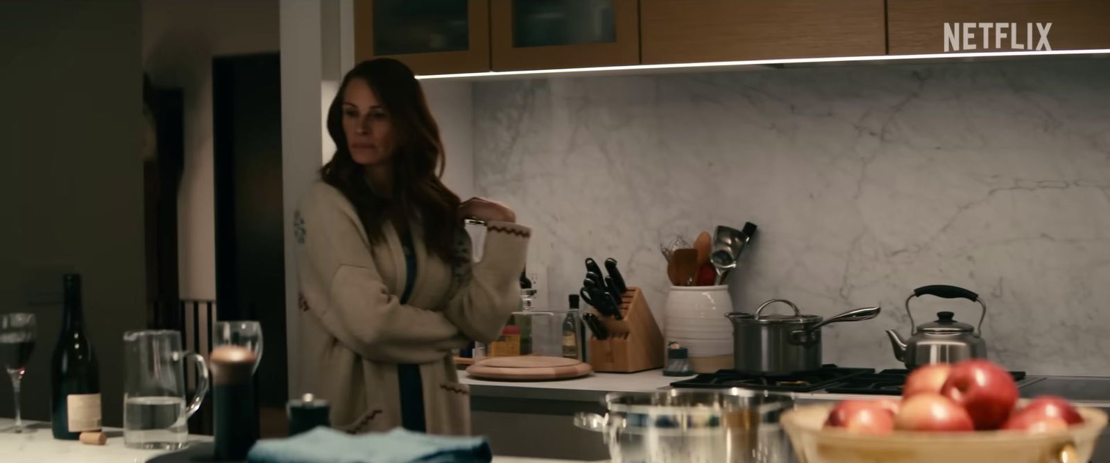 a woman standing in a kitchen preparing food