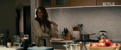 a woman standing in a kitchen preparing food